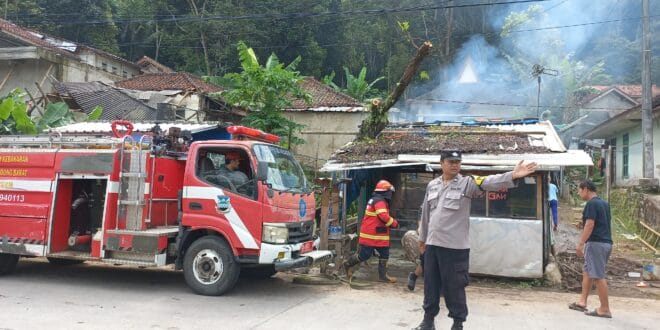 Keterangan Foto: Petugas Damkar dari Unit Cililin dibantu warga berjibaku memadamkan sisa api yang melalap warung milik keluarga A. Arman Molana di Kp. Cikakak, Desa Batulayang, Selasa (9/9/2025).